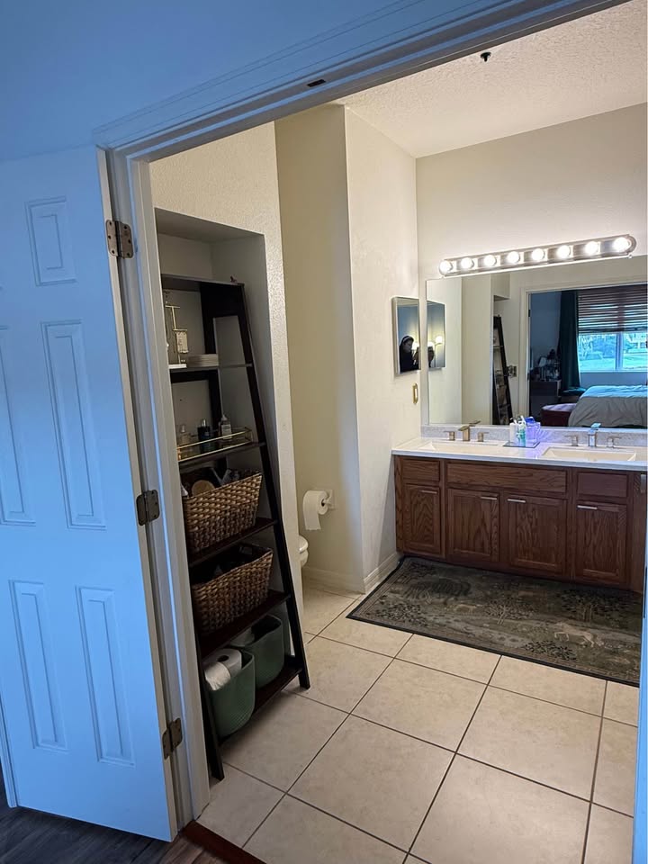 Primary bathroom with double vanity and walk-in closet